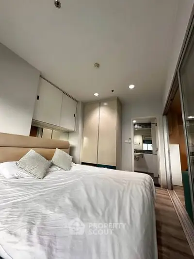 Spacious bedroom with modern design and ensuite bathroom, featuring ample storage and cozy ambiance.