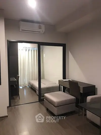 Modern apartment interior with sliding glass doors and sleek furniture design.