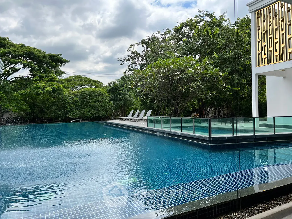 Luxurious outdoor pool area with modern design and lush greenery, perfect for relaxation and leisure.