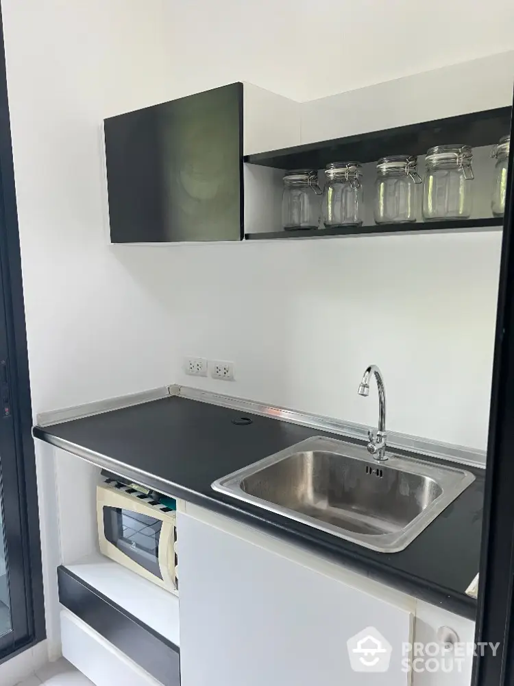 Modern kitchen with sleek black countertop and stainless steel sink