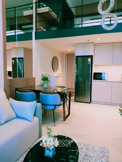 Modern open-plan living room and kitchen with stylish decor and loft area