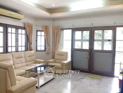 Spacious living room with elegant leather furniture and large windows