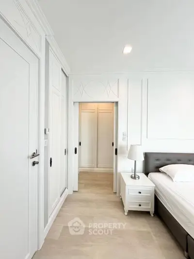Elegant bedroom with white decor and stylish wardrobe in modern apartment