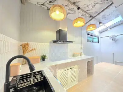 Modern kitchen with stylish lighting and sleek countertops in a contemporary home.