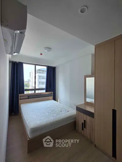 Modern bedroom with large window and stylish wooden furniture in a bright apartment.