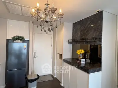 Modern kitchen with elegant chandelier and sleek black appliances