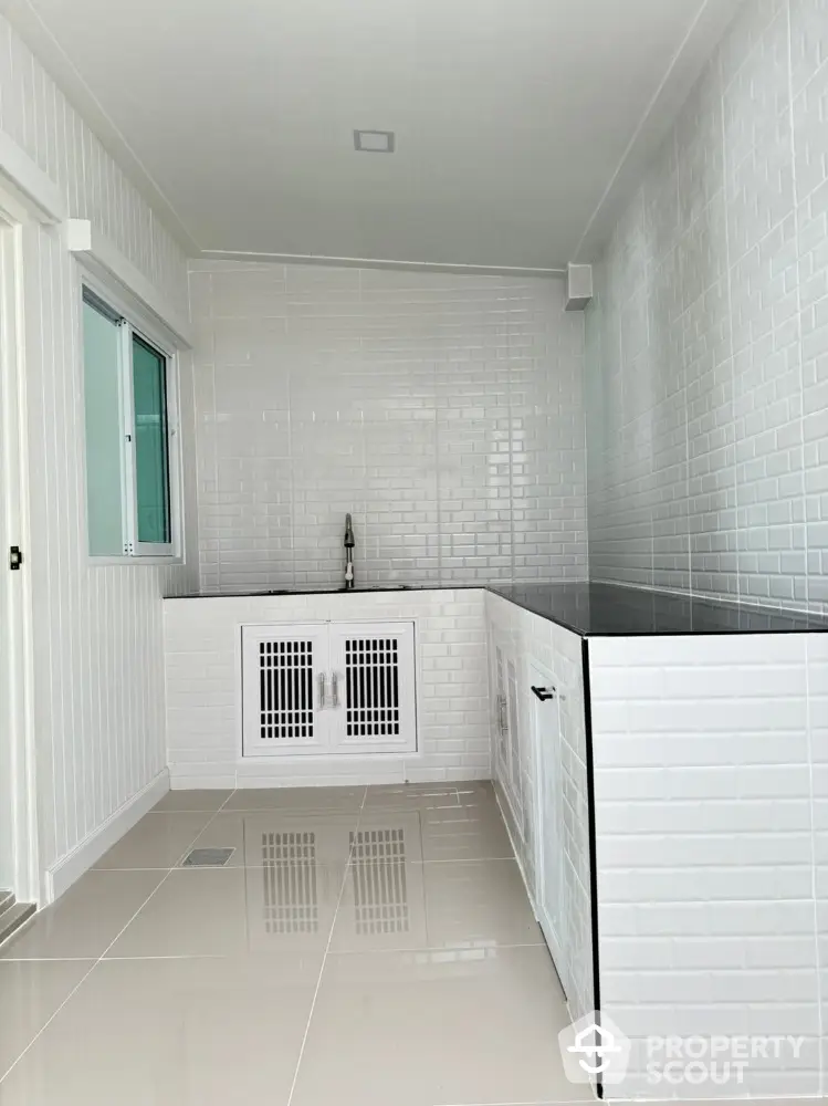 Modern minimalist kitchen with sleek white tiles and built-in sink