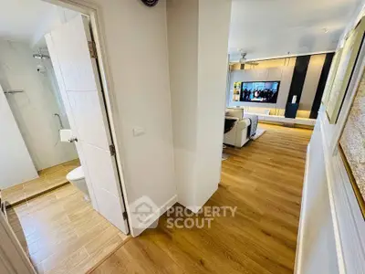 Modern apartment interior with open living room and bathroom, featuring wooden flooring and stylish decor.
