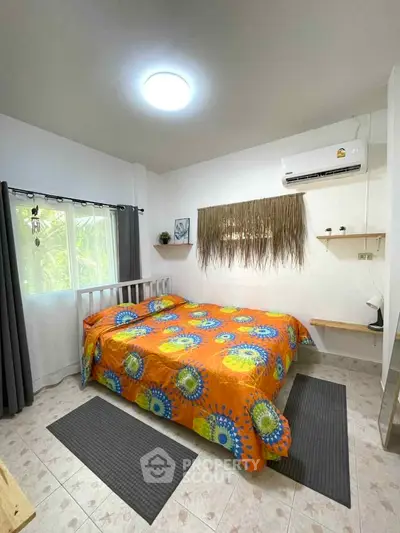 Cozy bedroom with vibrant bedding and air conditioning, perfect for relaxation.