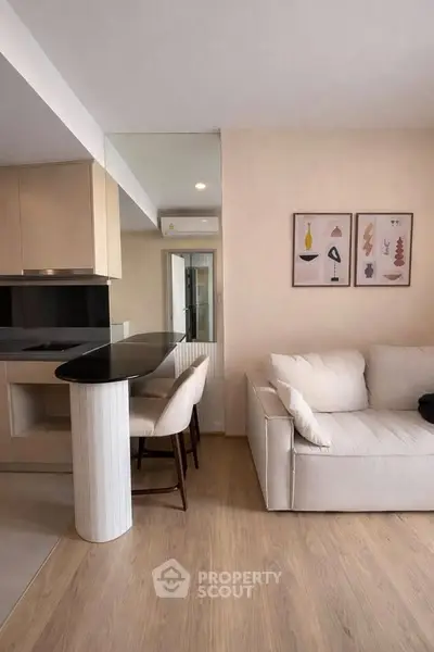 Modern living room with sleek kitchen and cozy seating area