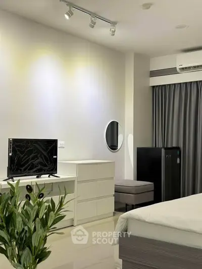 Modern bedroom with sleek furniture and air conditioning in a stylish apartment.