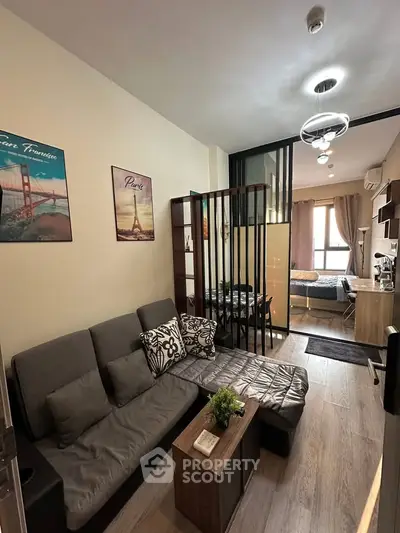 Modern living room with stylish decor and open layout leading to a cozy bedroom.