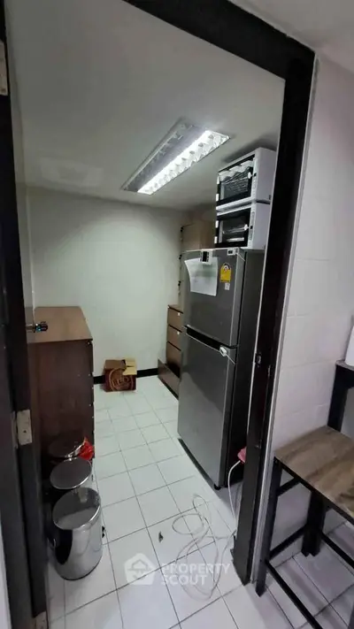 Compact kitchen with modern fridge and storage cabinets