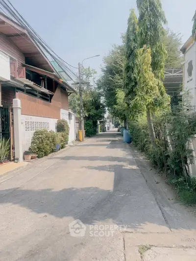 Charming residential street with lush greenery and cozy homes, perfect for serene living.