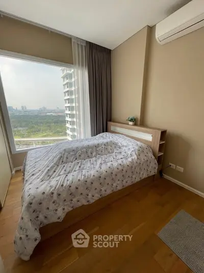 Cozy bedroom with large window offering stunning city view and modern decor.