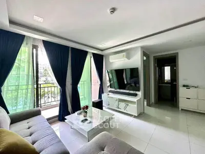 Modern living room with large windows, stylish furniture, and a sleek TV setup, perfect for relaxation.