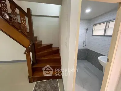 Charming interior with wooden staircase and modern bathroom, perfect for cozy living.