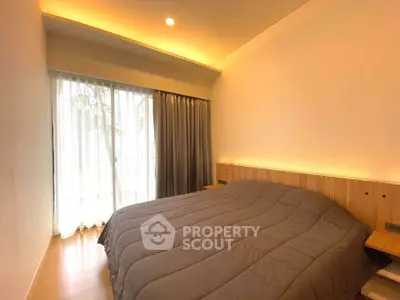 Cozy bedroom with modern lighting and large window for natural light