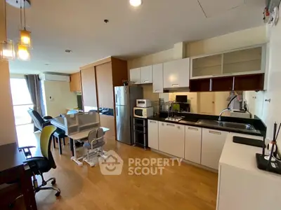 Modern open-layout kitchen with dining area and sleek appliances in a bright apartment.