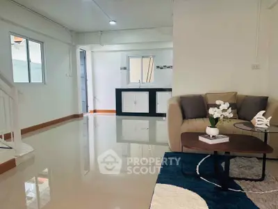 Spacious modern living room with sleek design and open layout, featuring a cozy sofa and elegant decor.