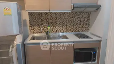 Modern compact kitchen with mosaic backsplash and built-in appliances