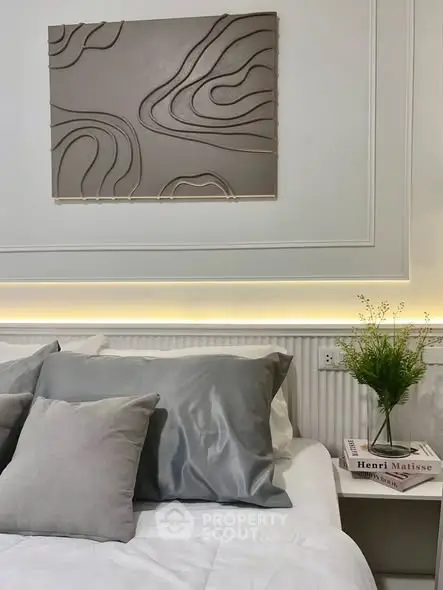 Elegant bedroom with modern decor and soft lighting, featuring stylish wall art and cozy bedding.