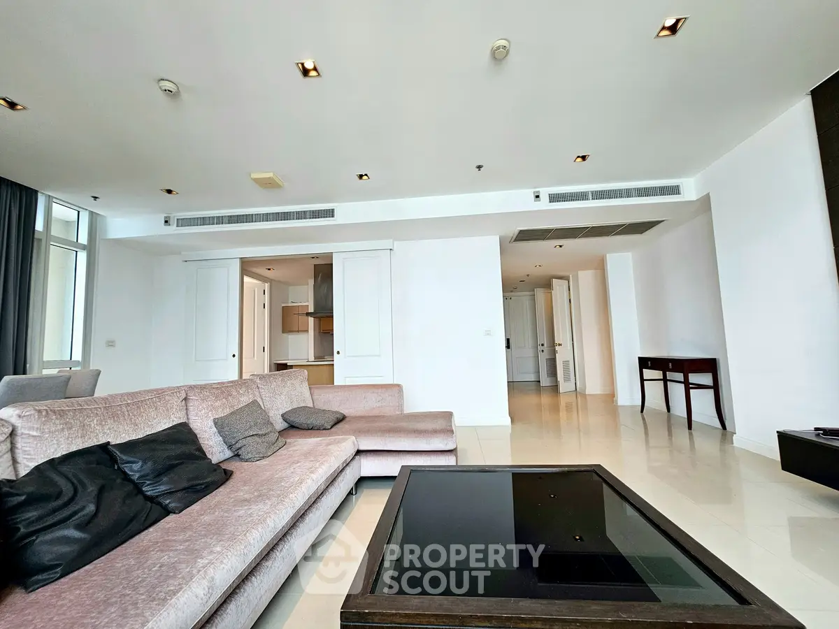 Spacious modern living room with elegant sofa and sleek design in luxury apartment.