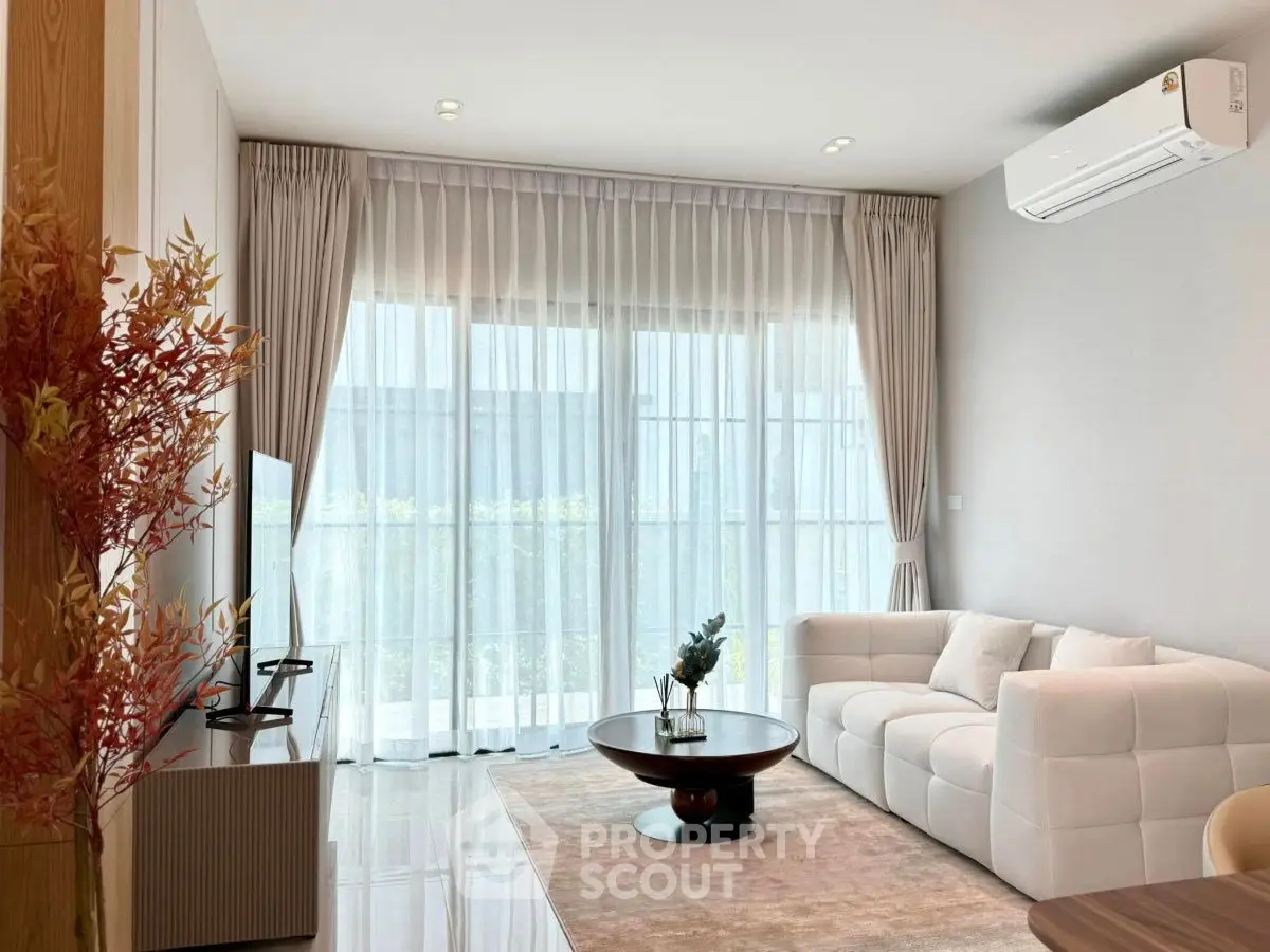 Elegant living room with plush sofa, modern decor, and large windows for natural light.