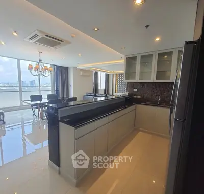 Luxurious open-layout kitchen with stunning city view and elegant dining area.