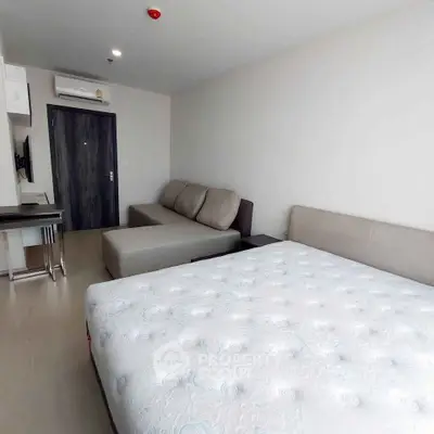 Modern studio apartment with cozy living area and comfortable bed, ideal for urban living.