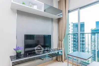 Modern living room with sleek TV setup and city view balcony, perfect for urban living.