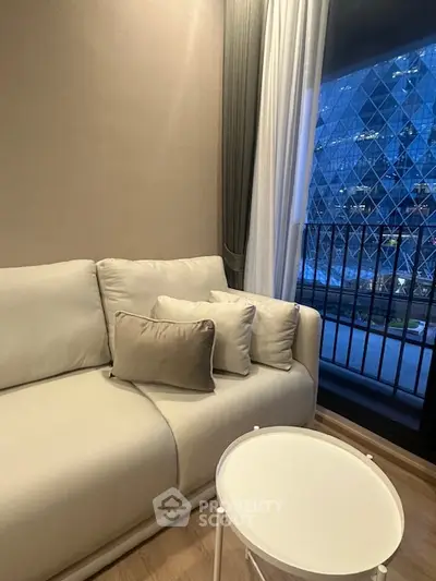 Modern living room with elegant sofa and city view from balcony.