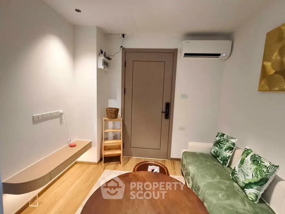 Cozy living room with modern decor and air conditioning, featuring a stylish wooden table and comfortable seating.