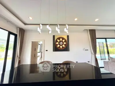 Luxurious modern living room with elegant lighting and stylish decor, featuring large windows and pool view.