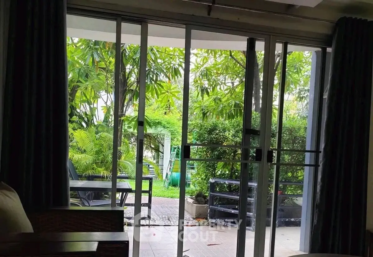 Spacious patio view with lush greenery from sliding glass doors