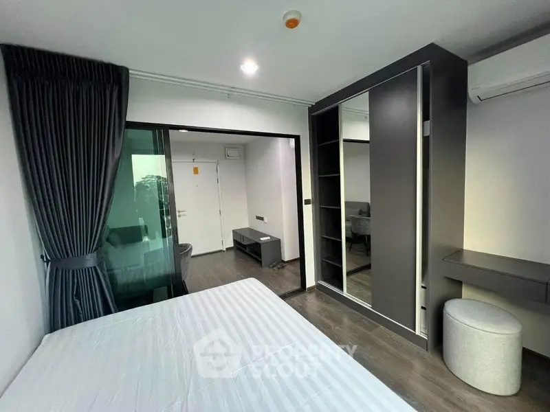 Modern bedroom with sleek wardrobe and stylish decor in a contemporary apartment.