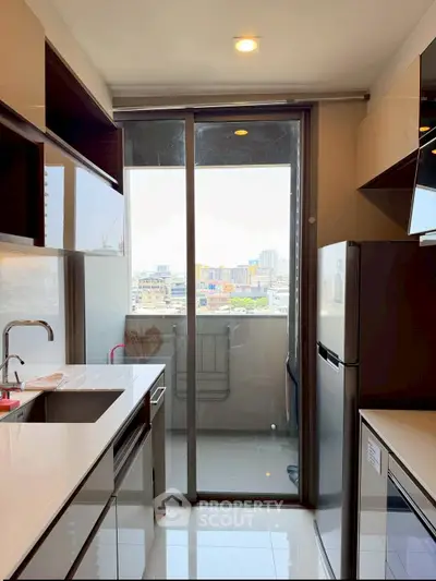 Modern kitchen with sleek appliances and balcony view in urban apartment