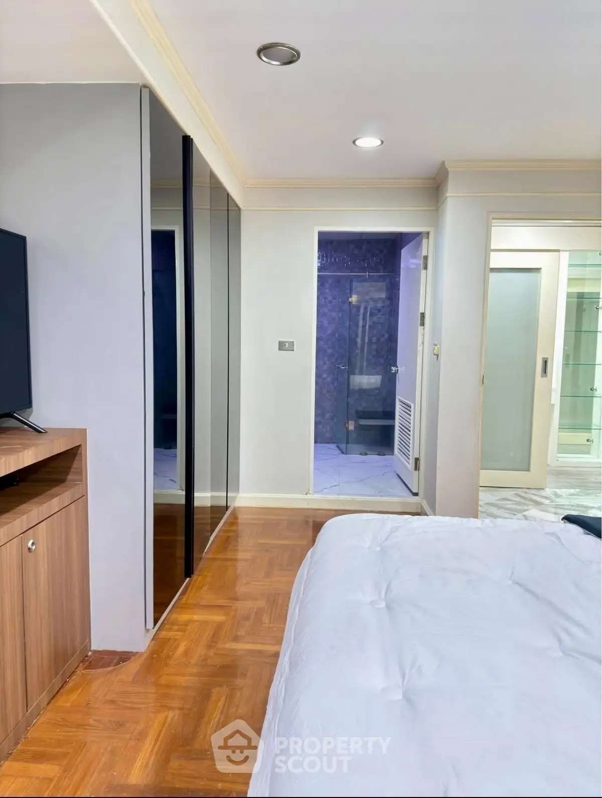 Spacious bedroom with modern decor and ensuite bathroom in a stylish apartment.