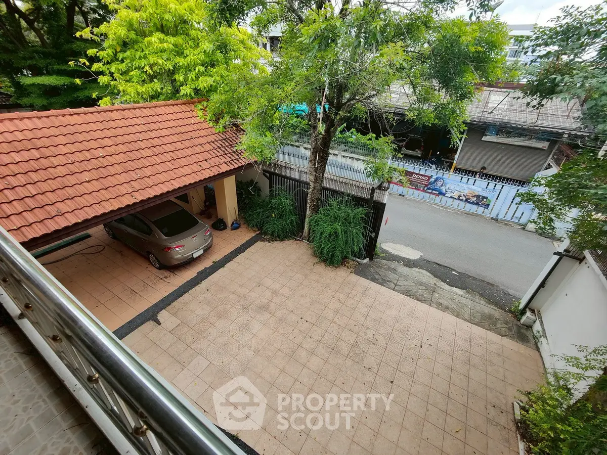 Charming residential driveway with carport and lush greenery