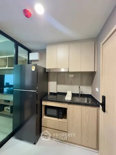 Modern compact kitchen with sleek appliances and wooden cabinetry