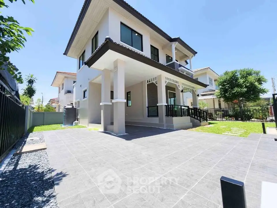 Modern two-story house with spacious driveway and lush garden in a serene neighborhood.