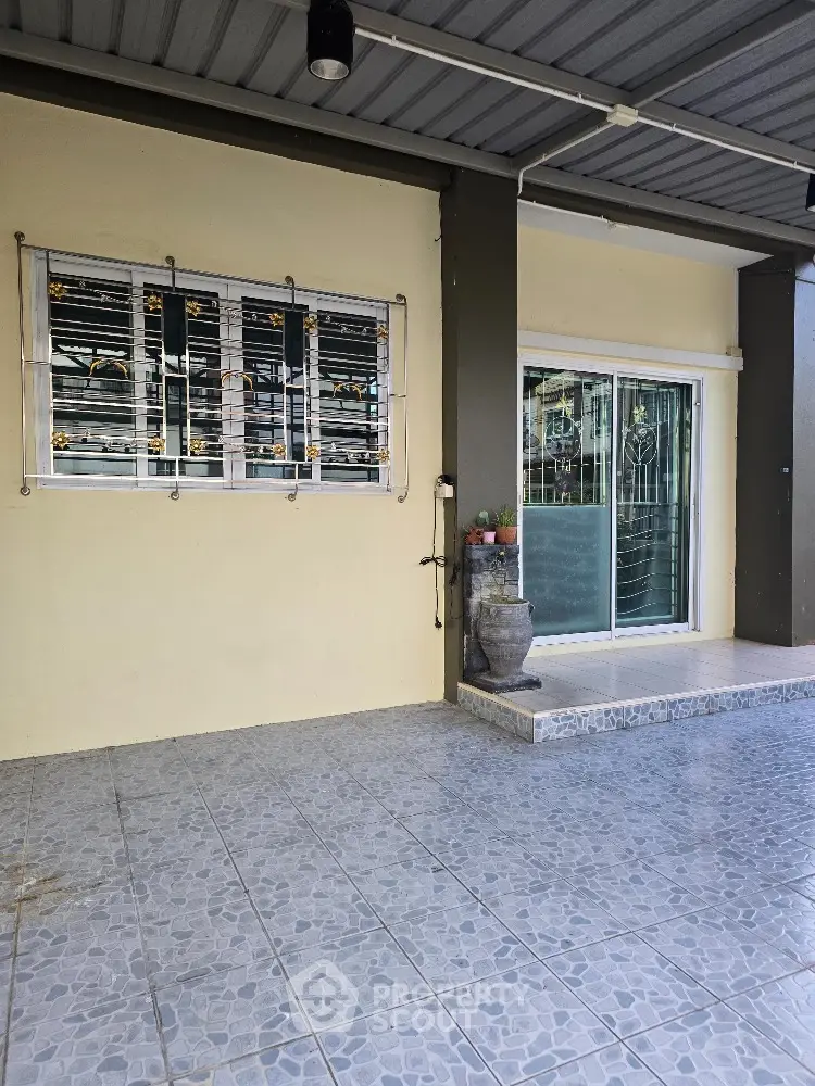 Charming home entrance with tiled patio and secure window grills