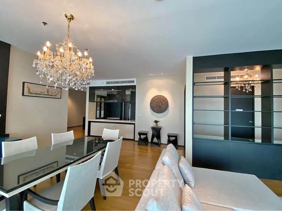 Luxurious dining and living area with elegant chandelier and modern decor