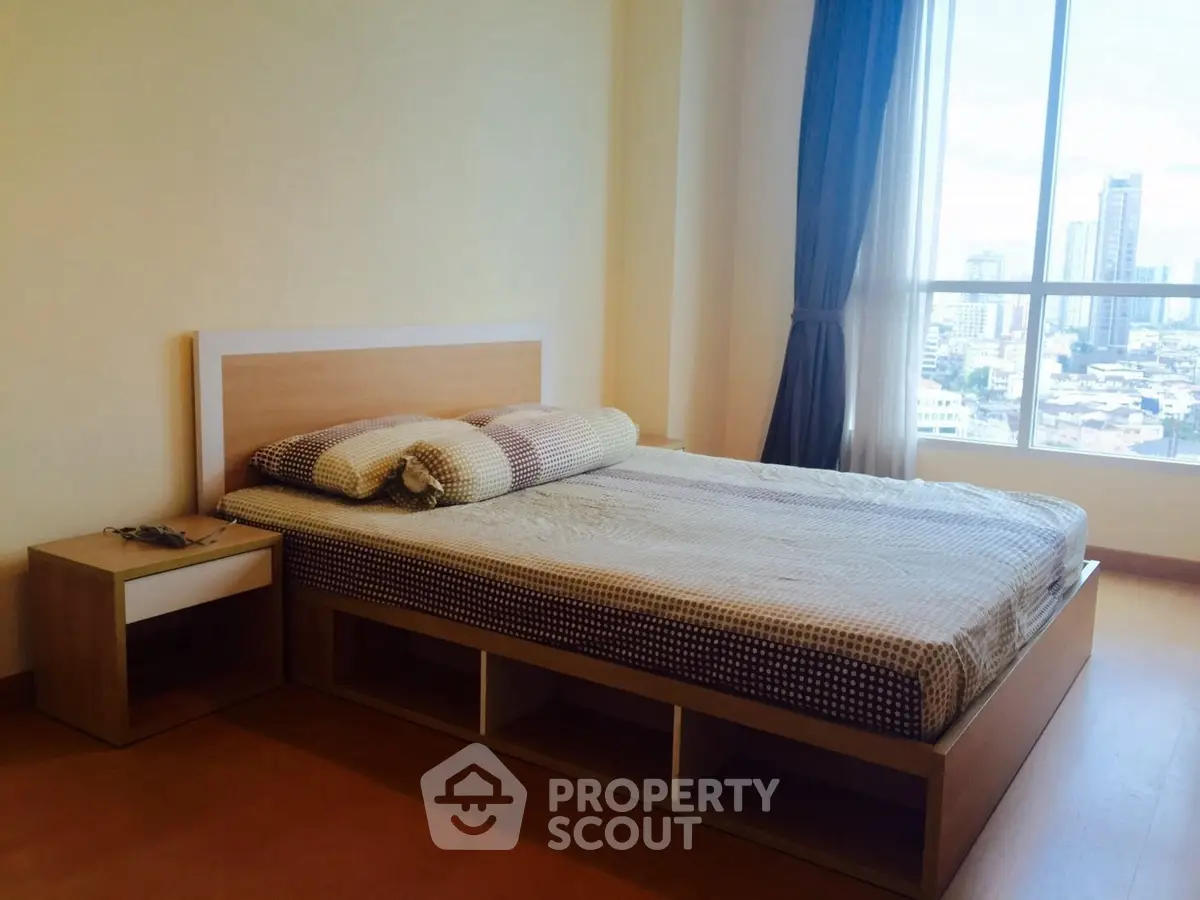 Modern bedroom with city view, featuring a stylish bed and large window.