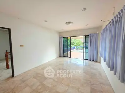 Spacious living room with large windows and balcony access