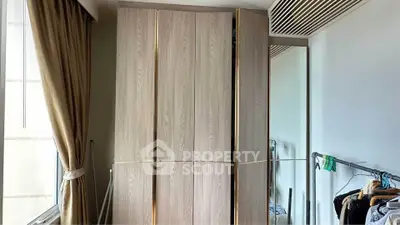 Spacious bedroom with elegant wardrobe and natural light through large window.