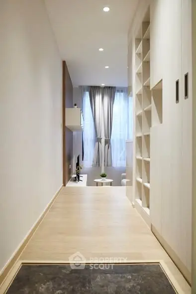 Modern minimalist hallway leading to a cozy living room with natural light.