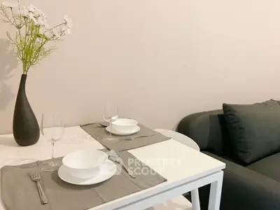 Modern dining area with elegant table setting and cozy sofa in stylish apartment.