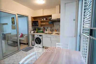 Modern kitchen with washing machine and dining area in compact apartment