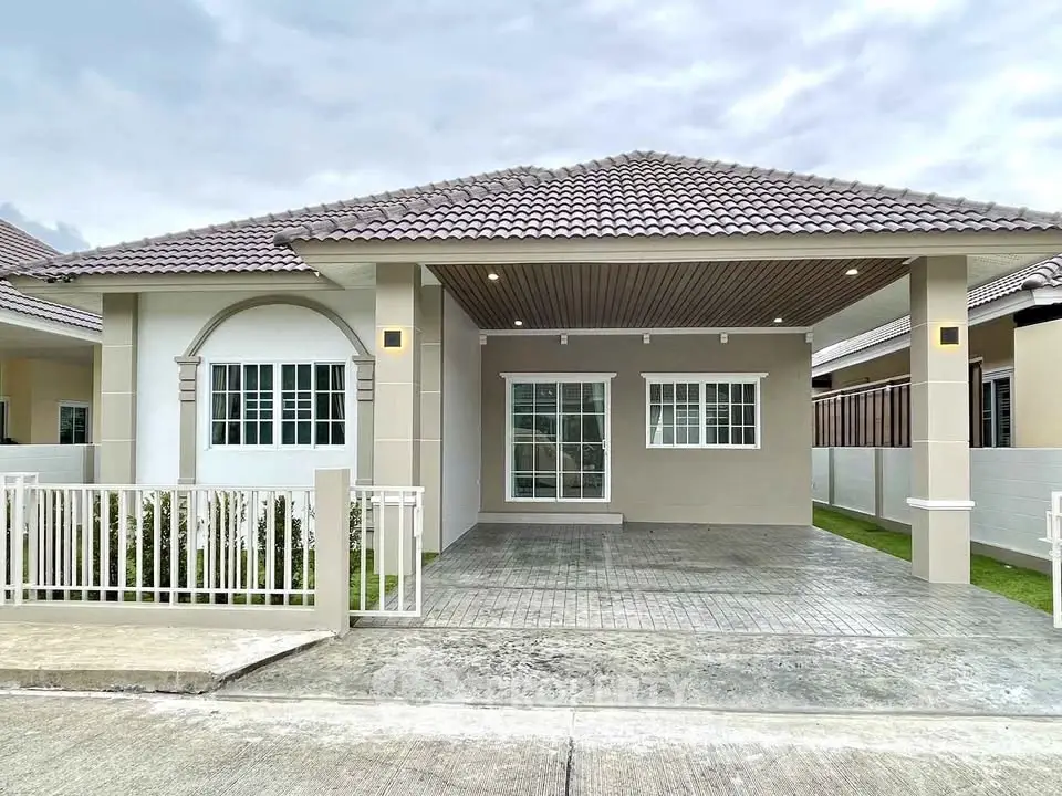 Charming single-story home with modern exterior and spacious driveway in a serene neighborhood.